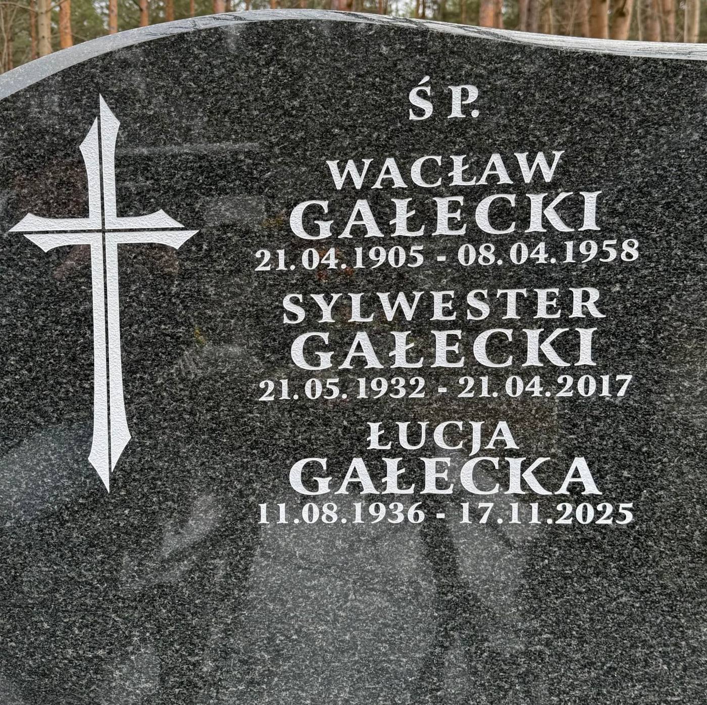 Nagrobek z białymi literami: Wacław, Sylwester i Łucja Gałeccy, obok piaskowany krzyż
