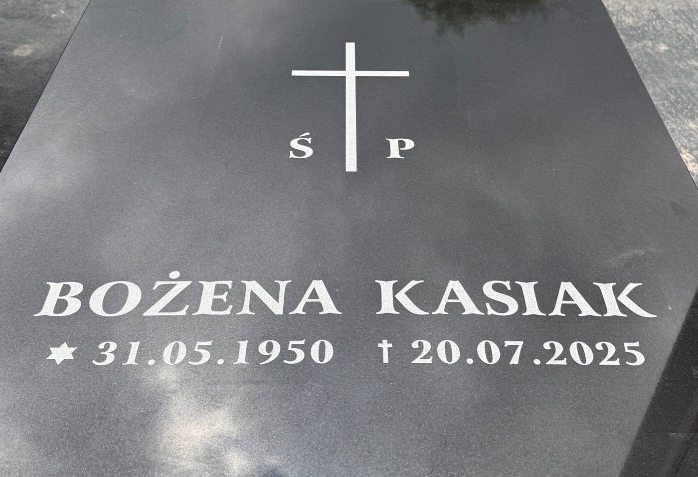 Napis Bożeny Kasiak z krzyżem na czarnej płycie